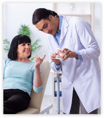 denture consultation denturist showing a denture model to a patient during a denture consultation