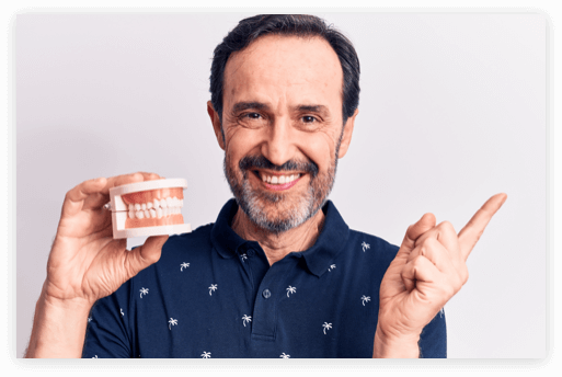 Patient Holding Dentures middle aged man holding a denture model