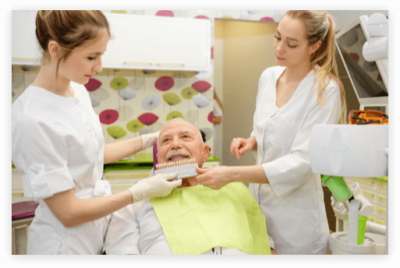 Shade Matching Dentures denture clinic staff colour matching an elderly man's teeth