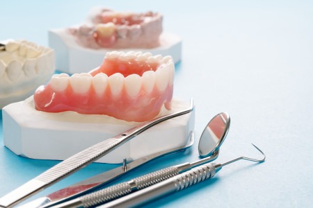 full repaired dentures on blue background