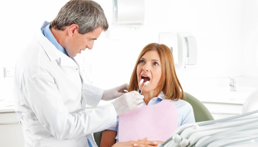 denturist observing the dentures of a denture patient
