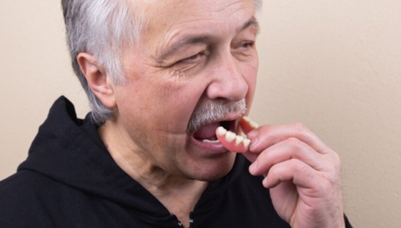 old man puts in dentures
