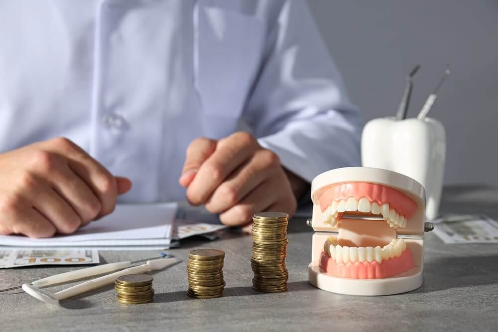 Investing in high quality dentures a set of dentures next to a stack of coins.