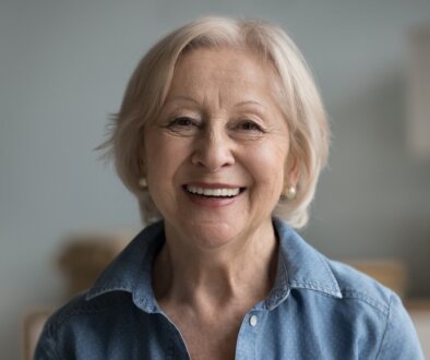 Smiling Retired Woman - How Do Dentures Stay in Place