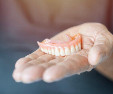 hand holding dentures