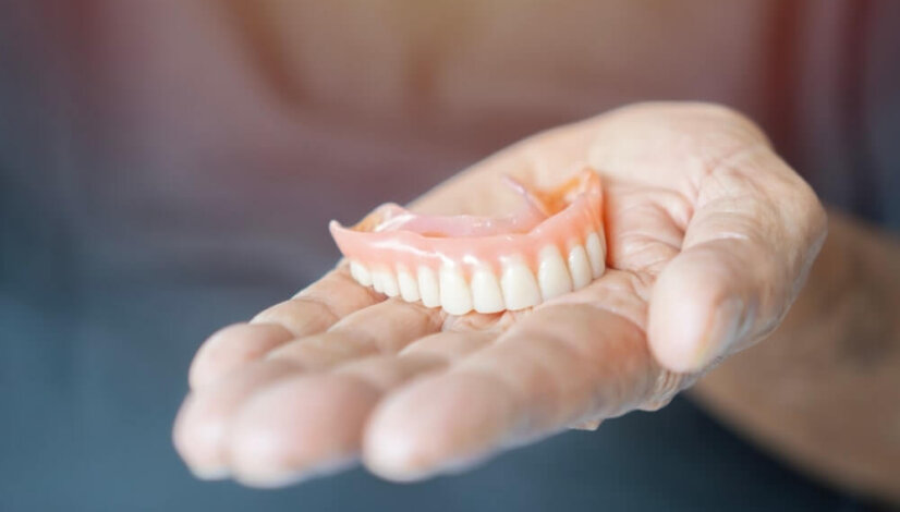 hand holding dentures