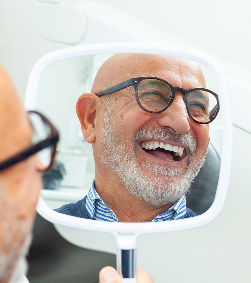 old man smiling after getting a denture repair